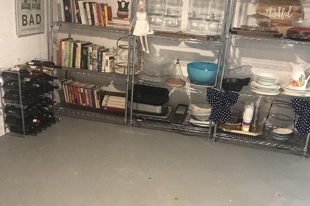 Closeup of organized basement shelving with wine rack and dishware