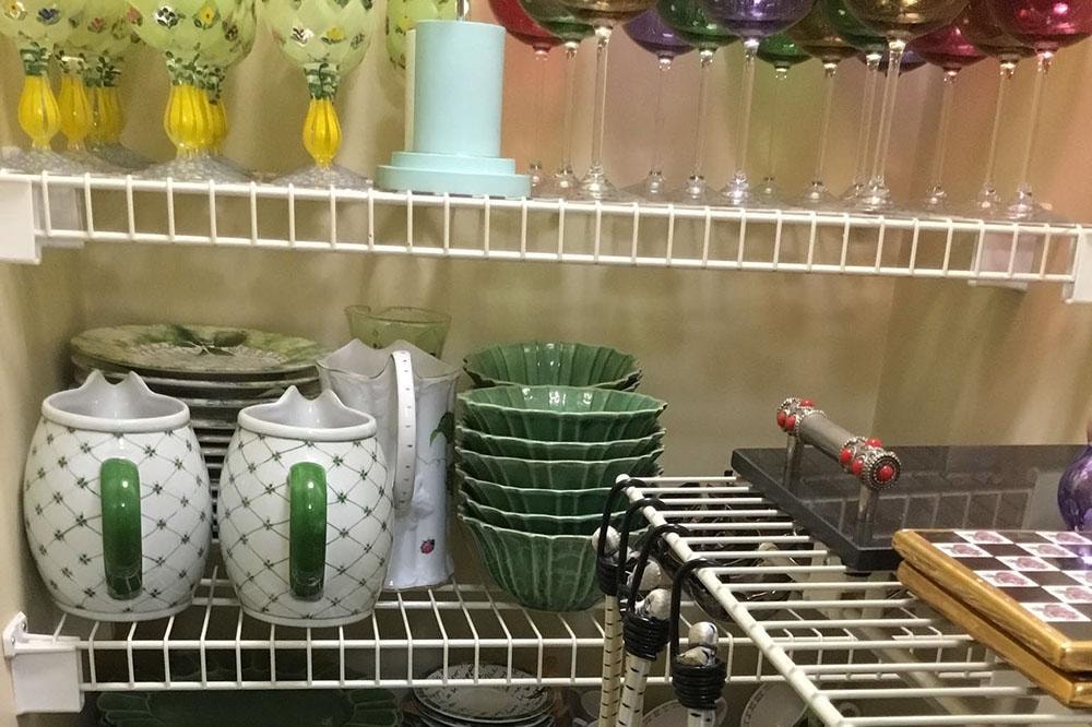Organized kitchen cabinet with colorful glassware and dishware