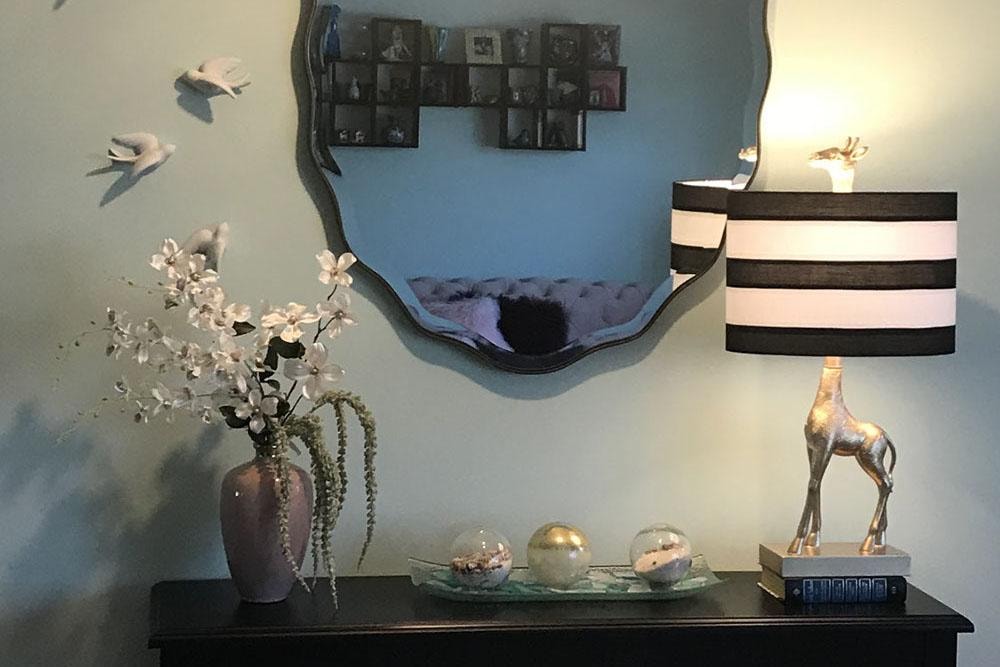 Styled entryway console with mirror, giraffe lamp, and decorative vase