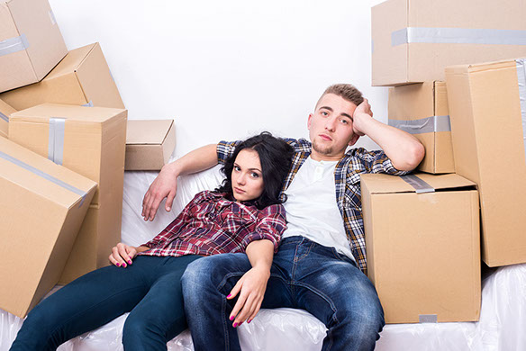 Young couple sitting among moving boxes